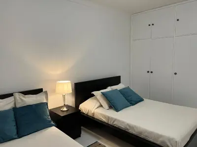 a bedroom with two beds with blue pillows at Pateo AL Albufeira in Albufeira