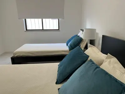 a bedroom with two beds with blue pillows at Pateo AL Albufeira in Albufeira