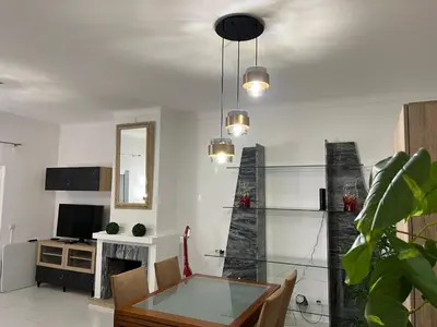 a living room with a glass table and a fireplace at Pateo AL Albufeira in Albufeira