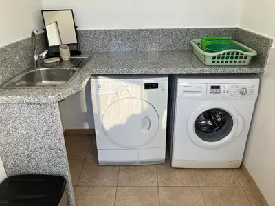 a kitchen with a washing machine and a sink at Vila Lana - Heated pool - Sea view - Two independent floors in Faro