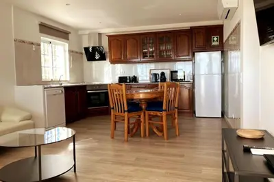 a kitchen with a table and chairs and a refrigerator at Vila Lana - Heated pool - Sea view - Two independent floors in Faro