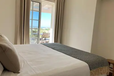 a bedroom with a bed with a view of a balcony at Vila Lana - Heated pool - Sea view - Two independent floors in Faro