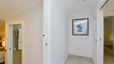 a hallway with white walls and a picture on the wall at Green Valley 03- CleverDetails, Monte Verde, lux, distant sea view, 3 bedroom, 4 saltwater pools in Vilamoura