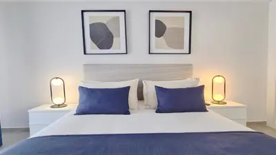 a bedroom with a bed with blue pillows and two lights at Green Valley 03- CleverDetails, Monte Verde, lux, distant sea view, 3 bedroom, 4 saltwater pools in Vilamoura