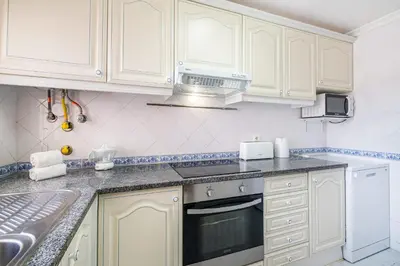a kitchen with white cabinets and a sink at Marina Vista Retreat in Albufeira