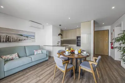 a living room with a blue couch and a table and chairs at Terracos de Quarteira II Eden by Real Properties in Quarteira