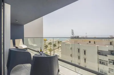 a balcony with two chairs and a view of a building at Terracos de Quarteira II Eden by Real Properties in Quarteira