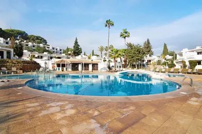 a large swimming pool with blue water at Ema Clube em Albufeira in Albufeira