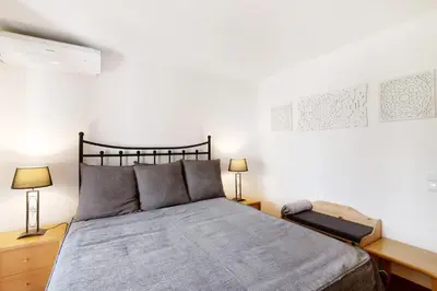 a bedroom with a large bed with two lamps at Ema Clube em Albufeira in Albufeira
