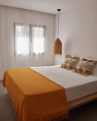 a bedroom with a large bed with an orange blanket at Casa Pateo in Albufeira