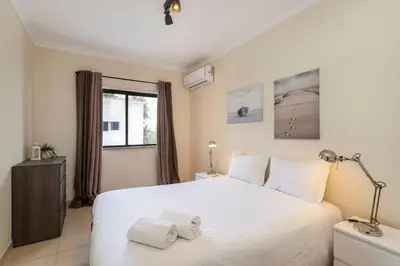 a bedroom with a white bed and a window at TAC - Sea Apartments 2D in Albufeira
