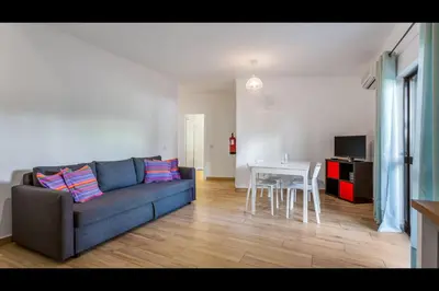 a living room with a couch and a table at Falésia Modern Flat W/Balcony & Pool by LovelyStay in Albufeira