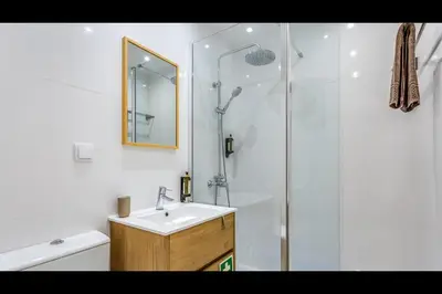 a white bathroom with a sink and a shower at Falésia Modern Flat W/Balcony & Pool by LovelyStay in Albufeira