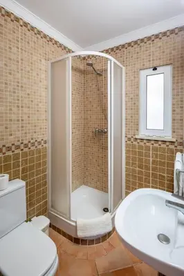 a bathroom with a shower and a toilet and a sink at 7+1 BEDROOM PRIVATE VILLA, HEATED POOL, GAMES, BBQ in Albufeira