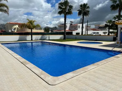 a large blue swimming pool in front of a house at Casa Rachael in Albufeira