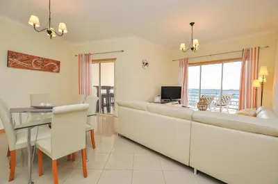 a living room with a large couch and a table at Encosta da Orada by OCvillas in Albufeira