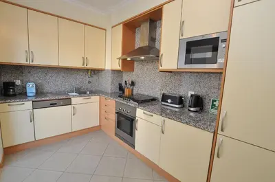 a kitchen with white cabinets and a stove top oven at Encosta da Orada by OCvillas in Albufeira