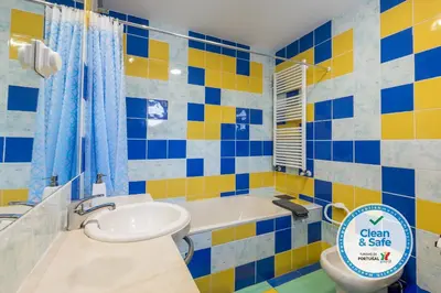 a blue and yellow bathroom with a sink and a toilet at Marina de Albufeira Villa 8 in Albufeira