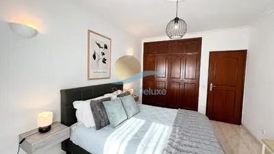 a bedroom with a large bed with a wooden door at Villa Bea by Sunny Deluxe in Albufeira