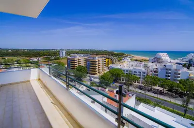 a balcony with a view of the beach and buildings at Dalia in Quarteira