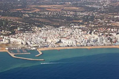a balcony with a view of the beach and buildings at Dalia in Quarteira