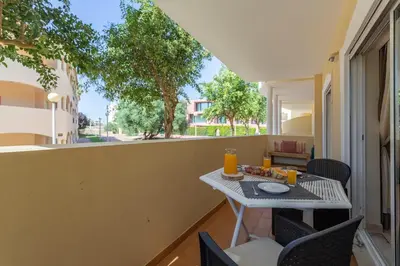 a table and chairs on a balcony with a table at Centralgarve - Spacious & Elegant - Vilamoura w Pool - Jacarandás in Quarteira