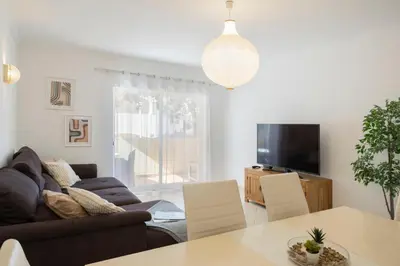 a living room with a couch and a table at Centralgarve - Spacious & Elegant - Vilamoura w Pool - Jacarandás in Quarteira
