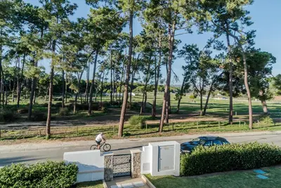 a person riding a bike down a street with trees at Falésia Cliff Apartment by The Portuguese Butler in Albufeira