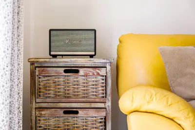 a laptop sitting on top of a table next to a yellow chair at Falésia Cliff Apartment by The Portuguese Butler in Albufeira