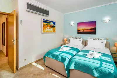 a bedroom with two beds with blue and white sheets at Falésia Cliff Apartment by The Portuguese Butler in Albufeira