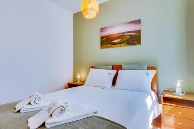 a bedroom with a white bed with towels on it at Villa Oliveiras de Vilamoura by The Portuguese Butler in Quarteira