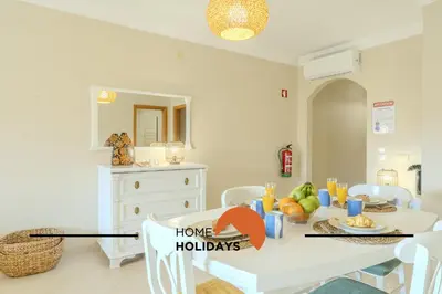 a dining room with a table with a home holidays sign on it at #130 Praia Village by Home Holidays in Vilamoura