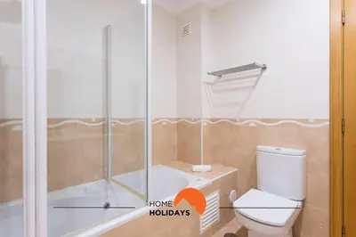 a bathroom with a shower and a toilet and a tub at #130 Praia Village by Home Holidays in Vilamoura