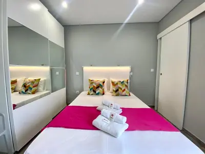 a small bedroom with a bed with towels on it at Quarteira Stylish 2 by Homing in Quarteira