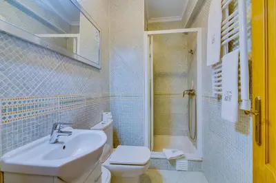 a bathroom with a sink and a toilet and a shower at Falésia Nature Villa by The Portuguese Butler in Albufeira