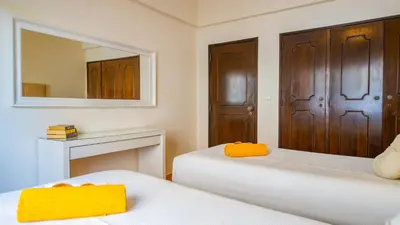 a room with two beds and a table and a bed at Villa Royal Sandals by Algarve Vacation in Albufeira