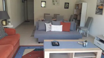 a living room with a blue couch with pillows at Apartamentos Mar-Sol Villas in Vilamoura