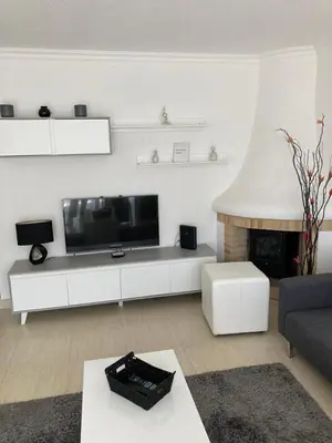 a living room with a television and a fireplace at Apartamentos Mar-Sol Villas in Vilamoura