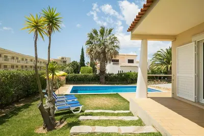 a villa with a swimming pool and palm trees at ABF36V2 Charming 2 bdr villa located only a few mi in Albufeira