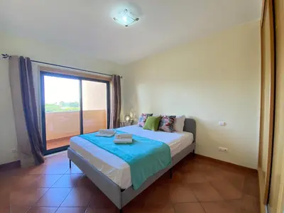a bedroom with a bed and a large window at Albufeira Sunny Style With Pool by Homing in Albufeira