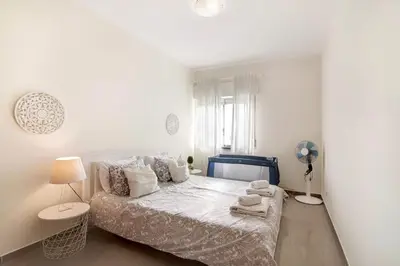 a white bedroom with a bed with towels on it at Matinhos House in Faro