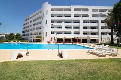 a swimming pool in front of a large building at Green 104 in Albufeira