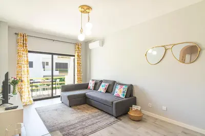 a living room with a couch and a window at Vilamoura - MAGNÓLIA 512 - T1 in Vilamoura