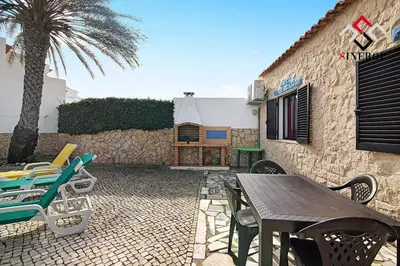 a patio with chairs and a table and a building at Villa Tigonema in Albufeira