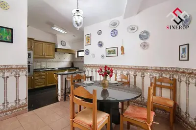 a kitchen with a table with chairs and plates on the wall at Villa Tigonema in Albufeira