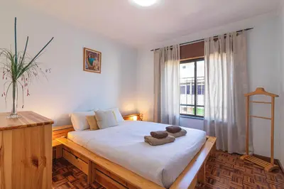 a bedroom with a large bed with two towels on it at Quarteira CONDESTÁVEL T3 in Quarteira