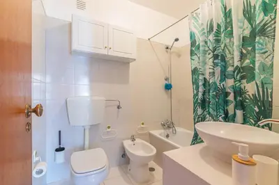 a white bathroom with a toilet and a sink at Quarteira CONDESTÁVEL T3 in Quarteira