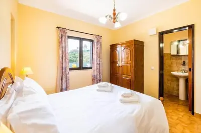 a bedroom with a large white bed and a sink at Villa Camila - Ideal location ten-min walk to Albufeira Marina in Albufeira