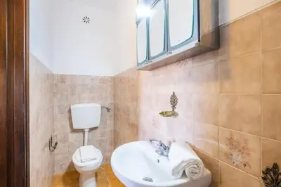 a bathroom with a toilet and a sink and a window at Villa Camila - Ideal location ten-min walk to Albufeira Marina in Albufeira