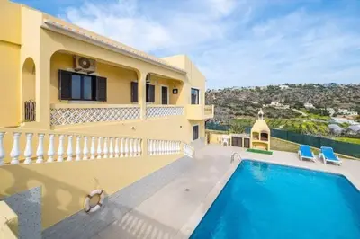 a villa with a swimming pool in front of a house at Villa Camila - Ideal location ten-min walk to Albufeira Marina in Albufeira